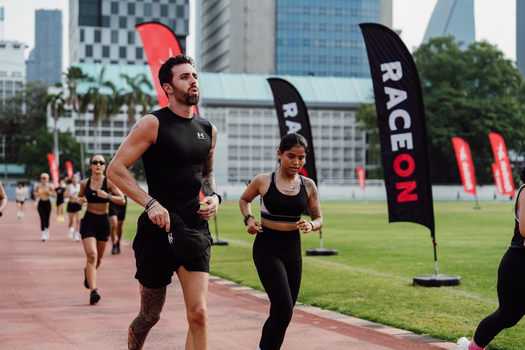 Luc running with a training group on a Bangkok track